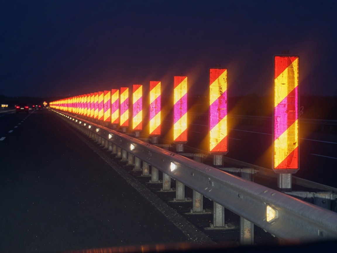 Highway guardrail delineators with reflective strips at night